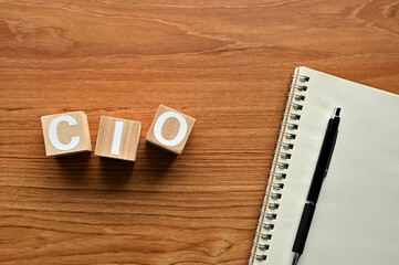 On a wood board, wooden word cubes are arranged in the letters CIO. It is an abbreviation for chief information officer.
