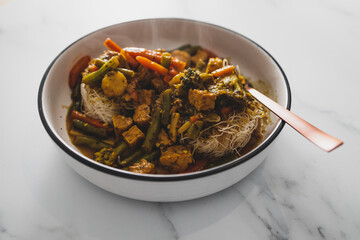 vegan asian-inspired noodles soup with mixed vegetables, healthy plant-based food
