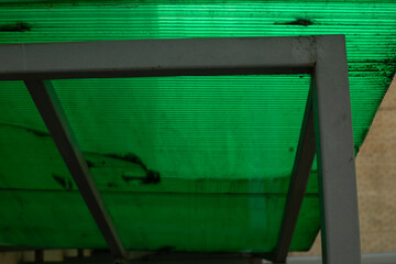 Green plastic roof on the structure. Simple roof on a metal profile. Modern building on the market.
