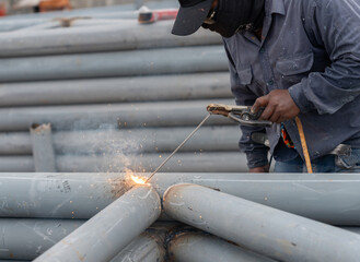 Worker welding the steel rod in construction site.