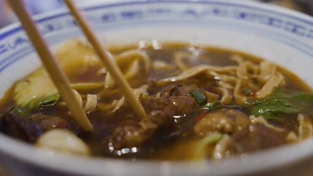 Close up of tasty yummy delicious Asian food hot herbal soup call "Bak kut teh soup" with smoke , pork rib dish cooked in broth popularly served in Thailand