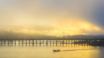 Fototapeta premium Aerial view and morning mist top view at Mon Bridge in sangkhlaburi,Kanchanaburi,Thailand. It is a popular place for tourists. Images may be blurry due to fog.