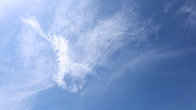 Strange shaped white clouds in the blue sky.