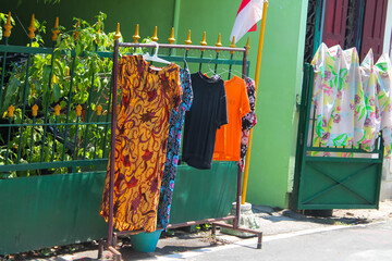 clothes hanging to dry on iron poles near the green gate