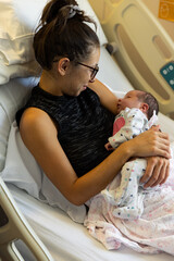 Mother and newborn baby lay in hospital bed