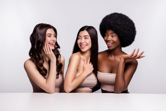 Photo of three young woman happy positive smile laugh speak conversation salon isolated over grey color background
