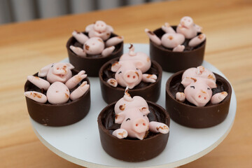 decorated candies, happy cute pink pigs playing in the mud