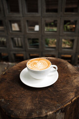 Latte art coffee on wooden table in coffee shop