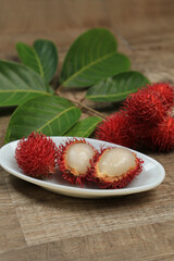 Rambutan on the table next to a tree branch. Fruit concept. Chinese fruit