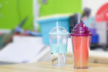 two plastic themal preserve cup color and transparent on table in room