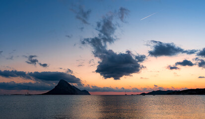 Fototapeta na wymiar Stunning view of the silhouette of Tavolara Island during a romantic sunrise. Porto Taverna, Sardinia, Italy.
