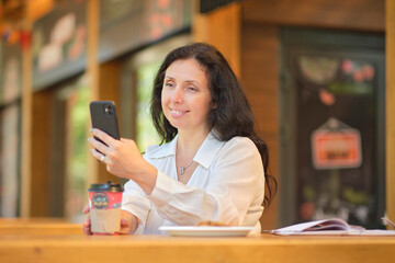 Cheerful elegant elderly woman chat with friends on a smartphone. Dating sites for seniors concept....