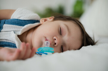 Cute little baby resting and sleeping with comfort at home on white bed