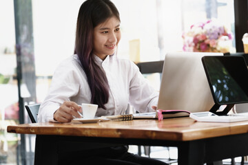 new normal, a businesswoman uses a computer to work for a company Via the internet on your desk at home.
