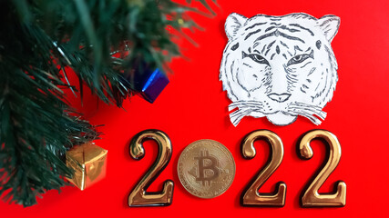 on a red background paper symbol of the year with gold numbers and bitcoin