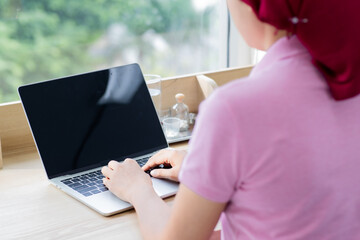 Caucasian business woman on casual pink shirt and red scarf do online marketing job by typing on laptop, searching info, and communicating work corperation for e-mommerce planing at cafe