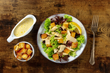 Chicken Caesar salad, overhead flat lay shot with the classic mayonnaise based sauce and croutons,...