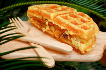 Delicious waffles on the wooden plate at garden.