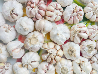 White garlic pile texture. Fresh garlic on market table closeup photo. Vitamin healthy food spice image. Spicy cooking ingredient picture. Pile of white garlic heads. White garlic head heap top view