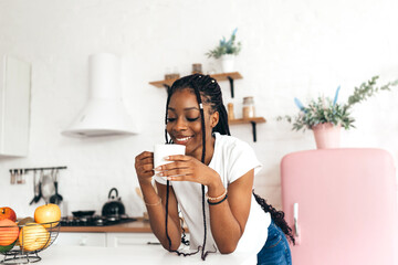 Portrait of young black woman drinking a cup of coffee or tea in the morning