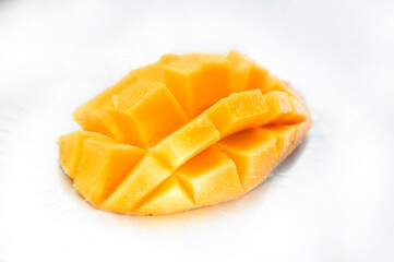 Fototapeta na wymiar Mango slice cut to cubes close-up isolated on white background