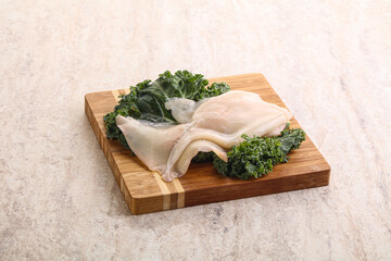 Raw squid over wooden board