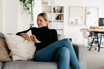 Slender young woman relaxing on a comfortable sofa