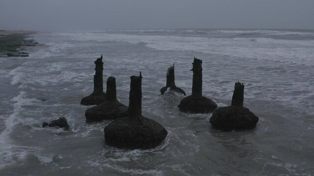 Okha Madhi or Madhi is a beautiful coastal area located between Bhatiya and Dwarka and is very isolated marine site. View of Water waves crash into concrete and stone pillars of ruined bridge