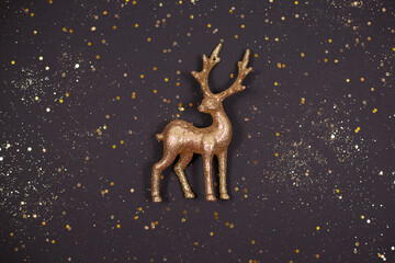 Obraz na płótnie Canvas Beautiful golden deer toy on festive black background.