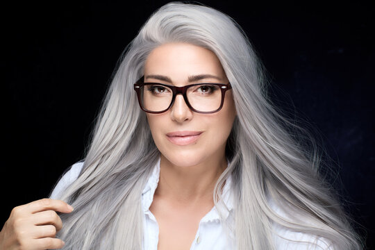 Beautiful mature woman with healthy long silver hair, wearing fashionable eyeglasses