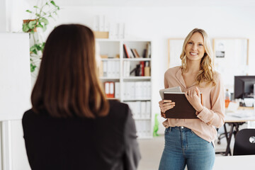 Young office trainee or employee in discussion with a manageress