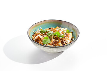 Pan asian traditional dish - fried rice with egg, vegetables, and squid. Indian wok with rice, egg and kalmar on white background. Nasi goreng with calamari on isolated background with shadows.
