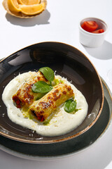 Italian beef cannelloni with bolognese ragu, bechamel sauce and cheese. Baked pasta cannelloni with meat and cheese parmesan. Italian aesthetic white table. Harsh shadow in Italian menu restaurant.