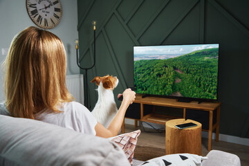Woman watching TV set on the sofa