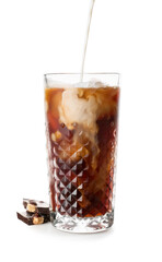 Pouring milk into glass of iced coffee on white background