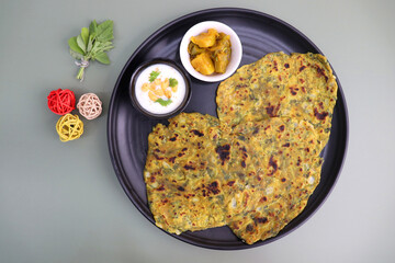 A Food called Methi paratha or Methi thepla is an Indian breakfast dish served with curd boondi...