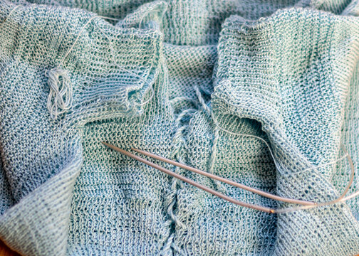 light blue cotton sweater, knitting close-up, handmade, knitting as a hobby