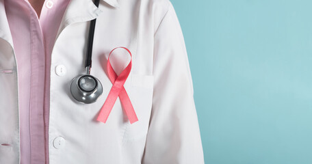 Breast cancer awareness concept. Doctor with pink ribbon and medical stethoscope on light blue...