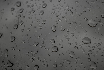 Drops of rain on a black dramatic window glass background. Autunm Rain, depression concept image.