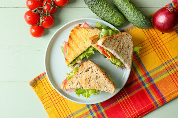 Plate with tasty sandwiches on color wooden background