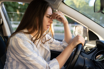 Tired young woman car driver suffering from headache migraine driving vehicle sit at driver seat...