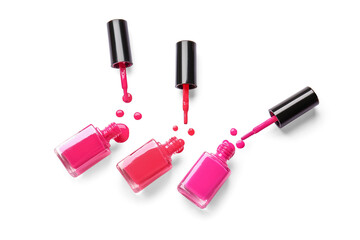 Bottles of nail polishes with brushes and blots on white background