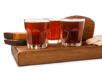 Glasses of fresh kvass and bread on white background