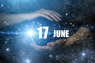 June 17th. Day 17 of month, Calendar date. Human holding in hands earth globe planet with calendar...