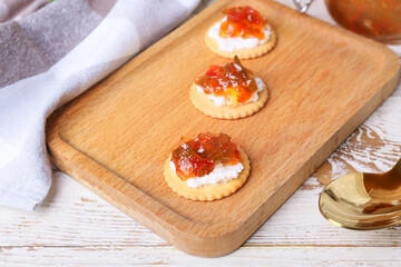Delicious crackers with cottage cheese and jalapeno pepper jam on wooden table