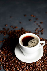 Warm cup of coffee with coffee beans over black background. Coffee time, copy space web design banner.