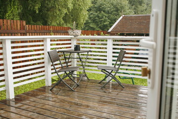 table and chairs on the veranda are wet from the rain. autumn