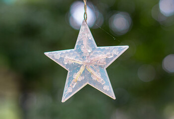 a photo of a hanging star with bokeh on background