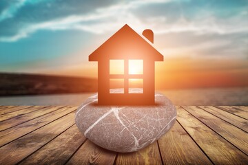 Small toy house on sea beach at sunset, family travel and summer vacation