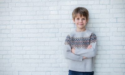 Portrait photo of adorable young happy caucasian boy looking at camera. Isolated on white wall background. School boy healthy lifestyle winter concept.